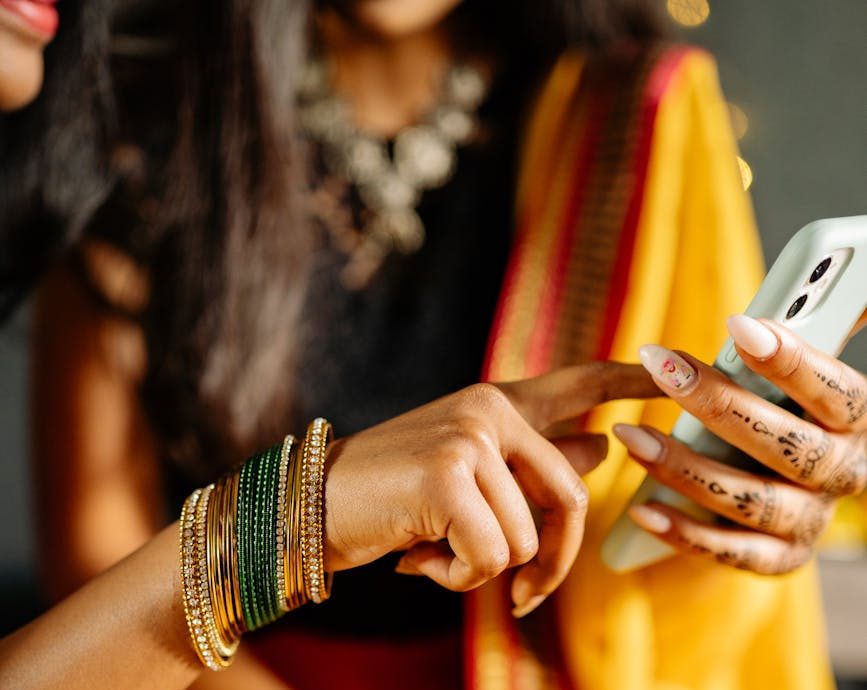 women in traditional dresses using phone